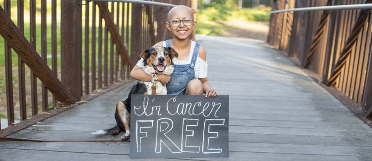 Sarah celebrates being cancer free with her dog.